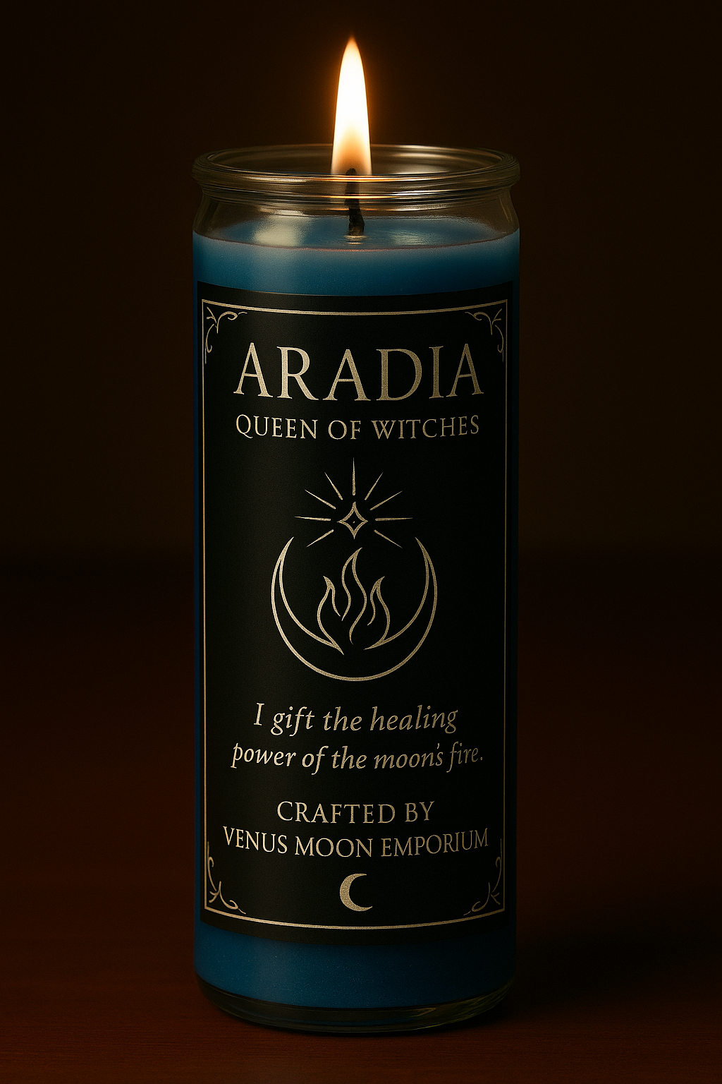Lit 7-day blue devotional candle with black and silver Aradia label reading “Queen of Witches.” The crescent moon and flame sigil glows in candlelight