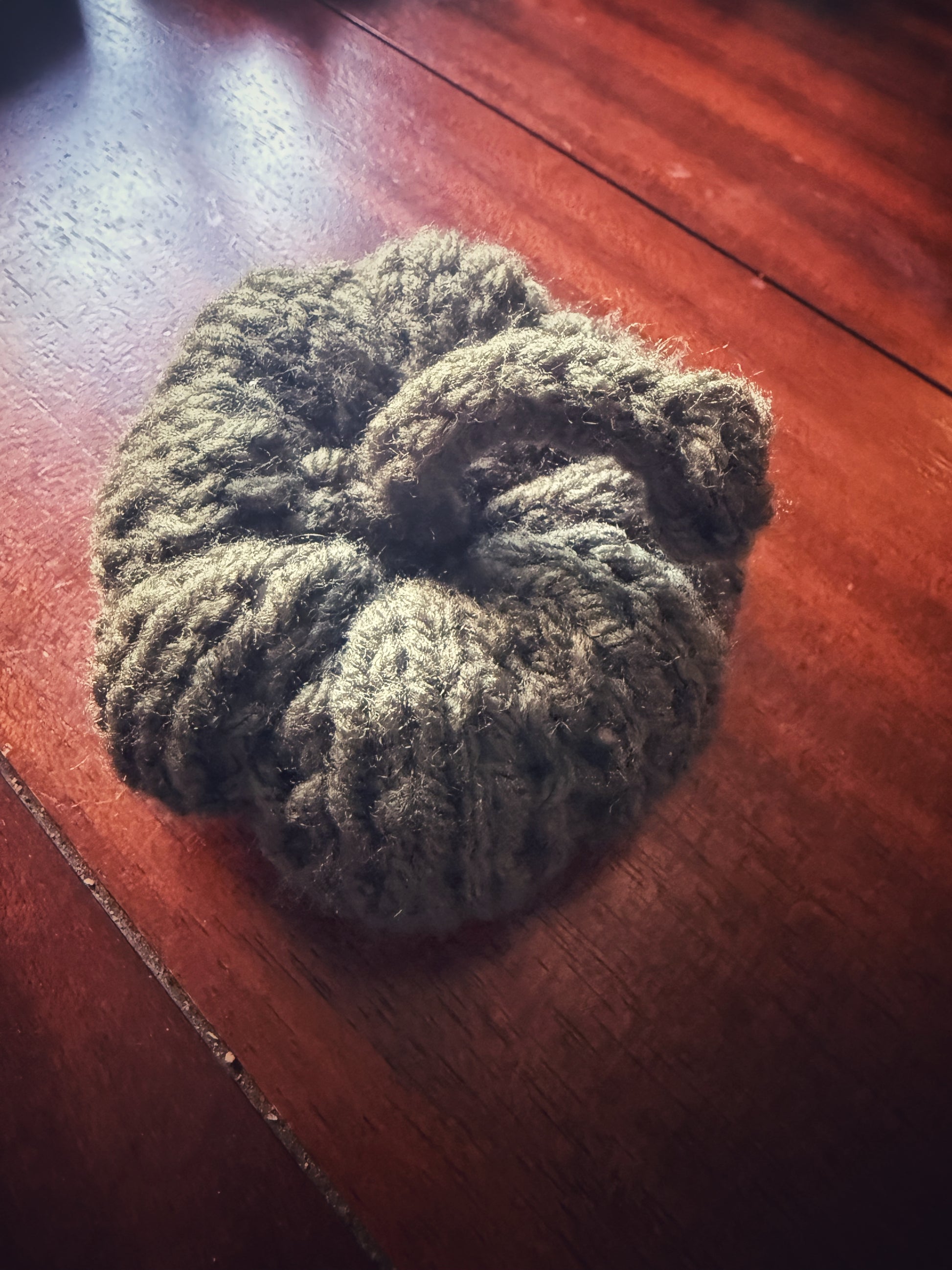 Hand-knit pumpkin in dark green, cozy fall décor piece.