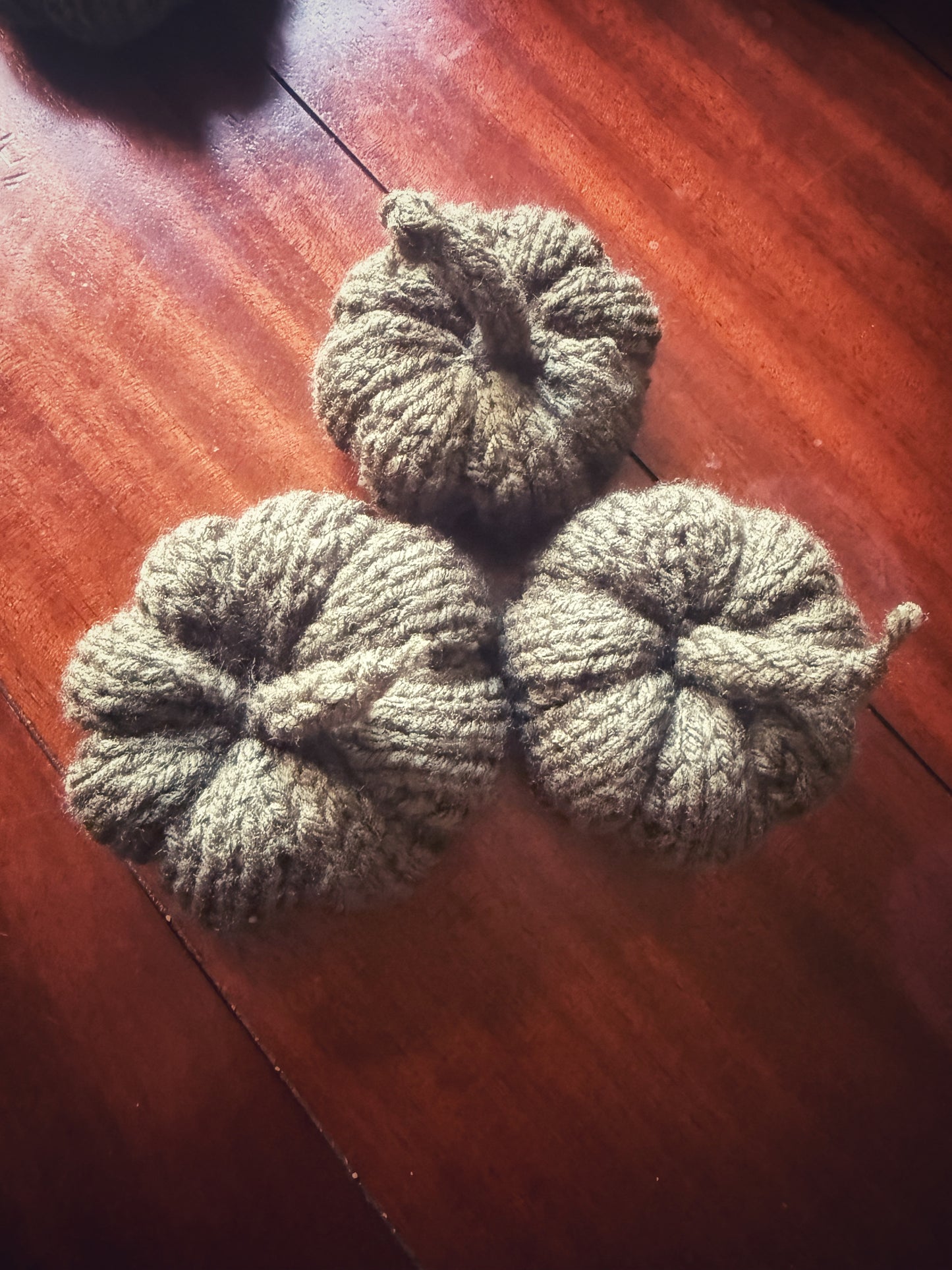 Handmade dark green knit pumpkins, autumn altar decoration.